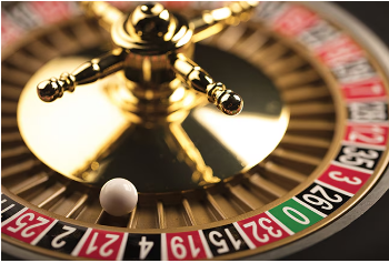 Close-up of a roulette wheel with a white ball resting near the number eight slot among numbered pockets.